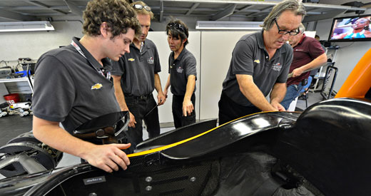Crew looks over the car of Buddy Lazier